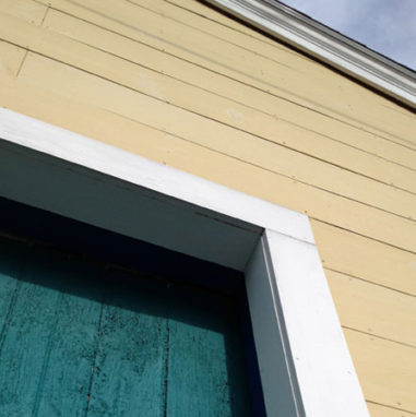 yellow boat house with green door in Rockland Maine